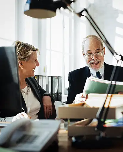 ein Kunde wird von einem Mitarbeiter am Schreibtisch zu seinem Serienversand beraten